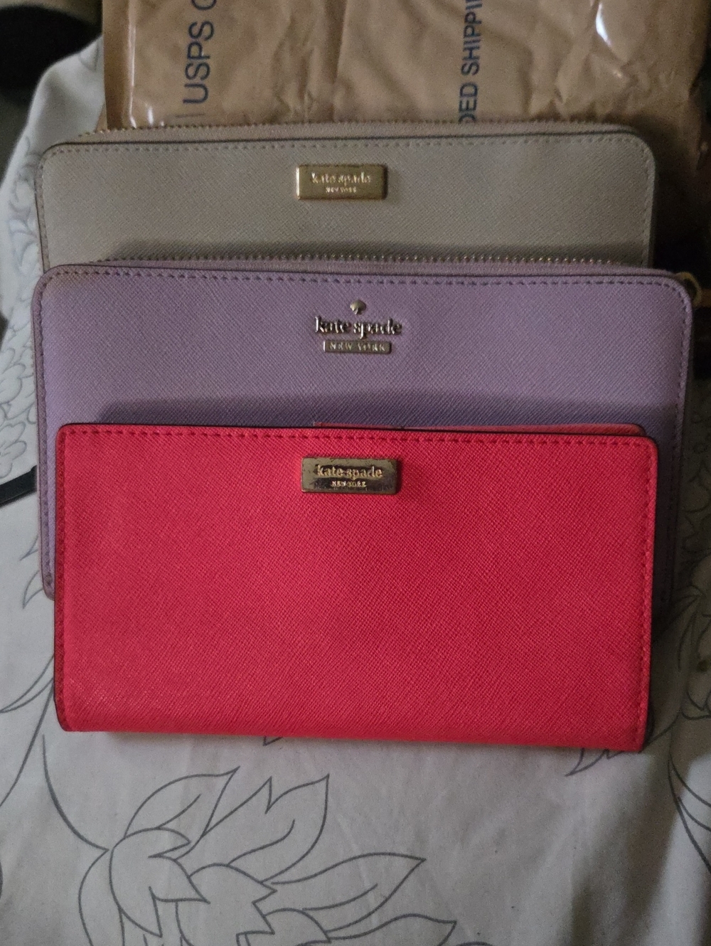 3 kate spade tri-color Saffiano zip wallets set in coral, lavender & beige